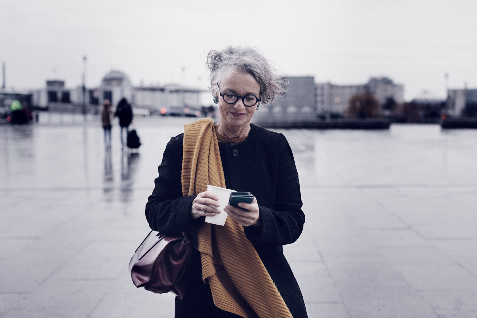 businesswoman-smiling-while-texting-on-her-lunch-break