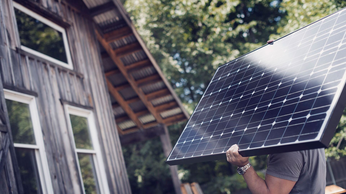 man-carrying-a-solar-panel