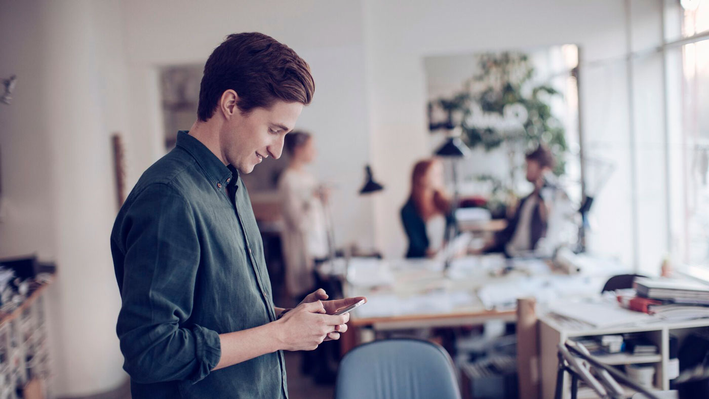 Young-man-with-phone-in-the-office