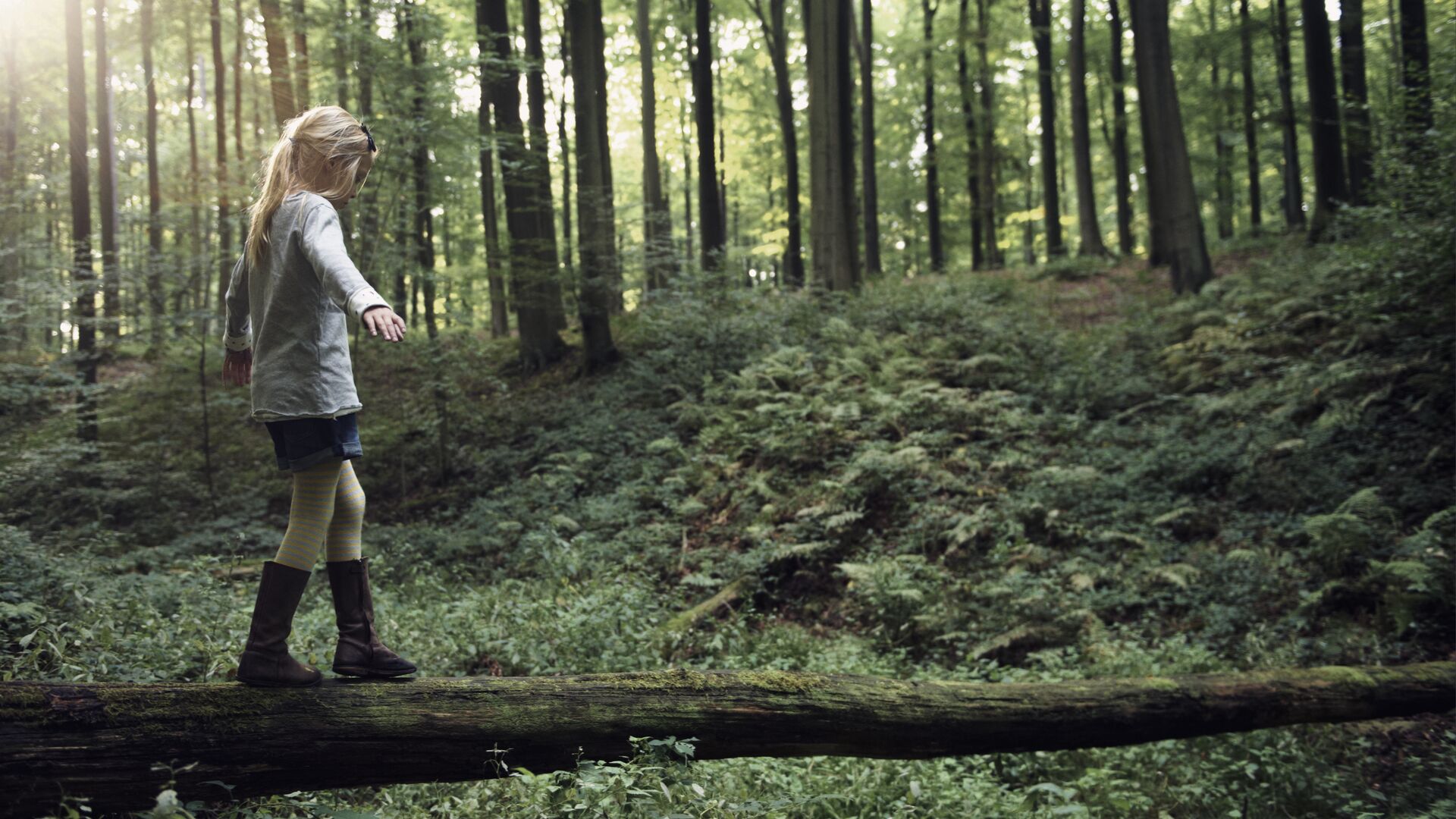 Girl walking on a tree trunk