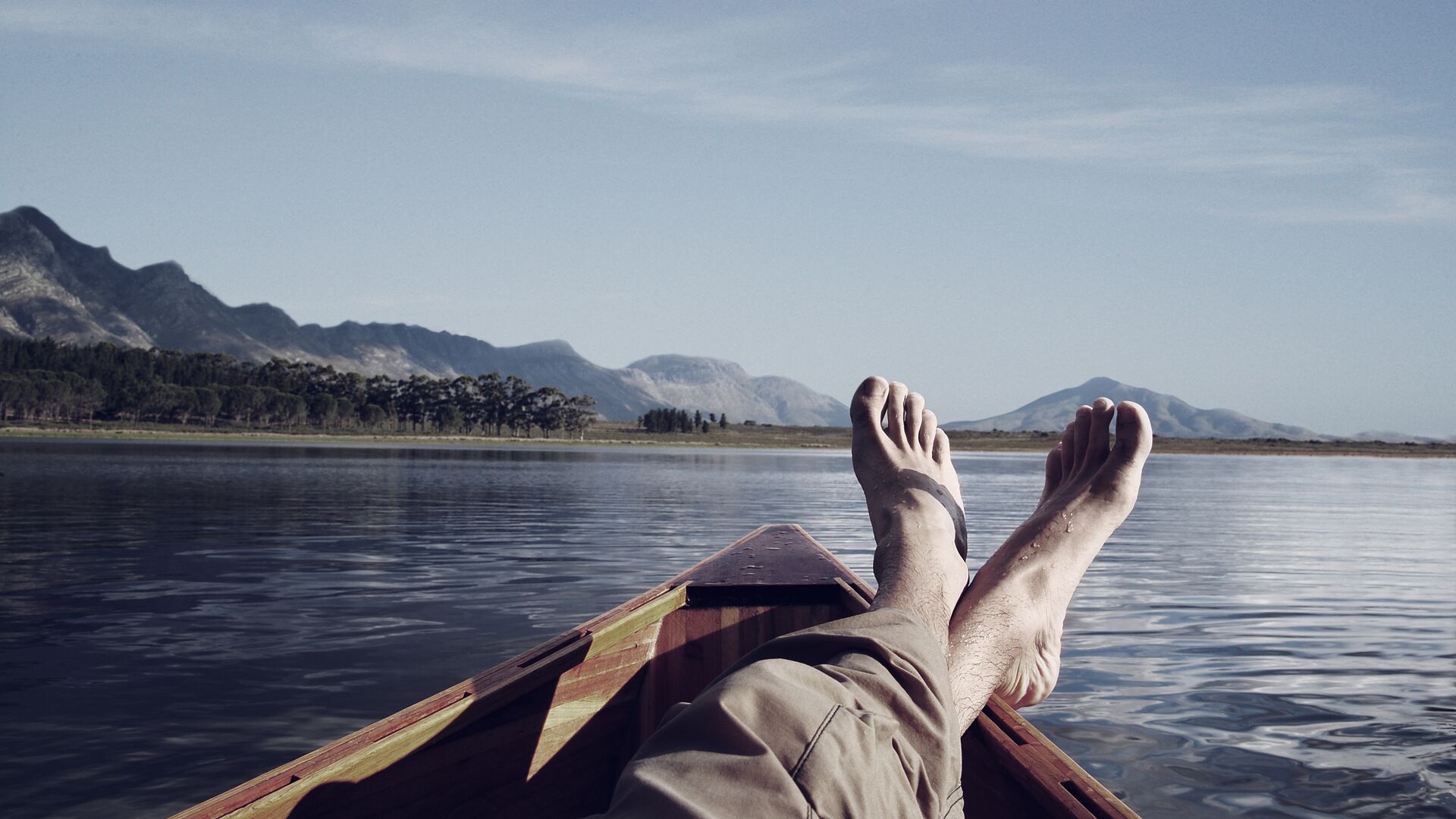 young-man-lying-in-boat-on-lake