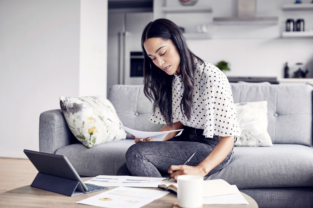 woman-analyzing-documents-while-sitting-at-home