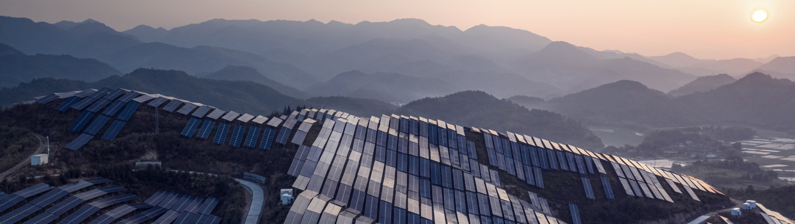 Aerial view of the solar power plant on the top of the mountain at sunset 
