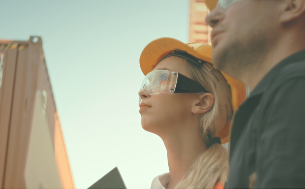 Woman wearing a hard hat and safety glasses.