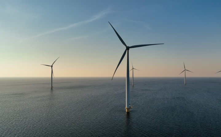 A group of wind turbines in the ocean.