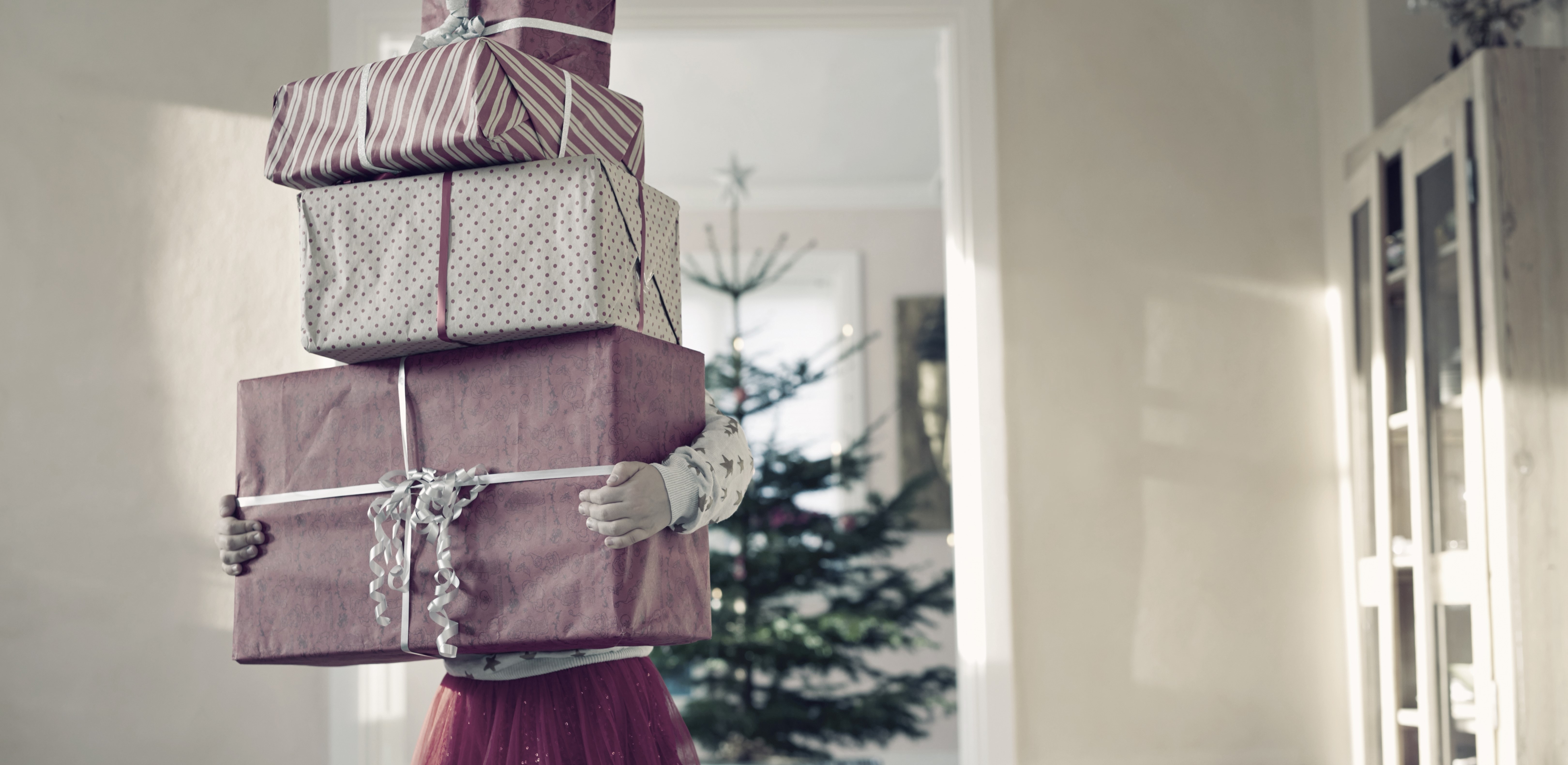 girl-holding-tall-stack-of-christmas-presents