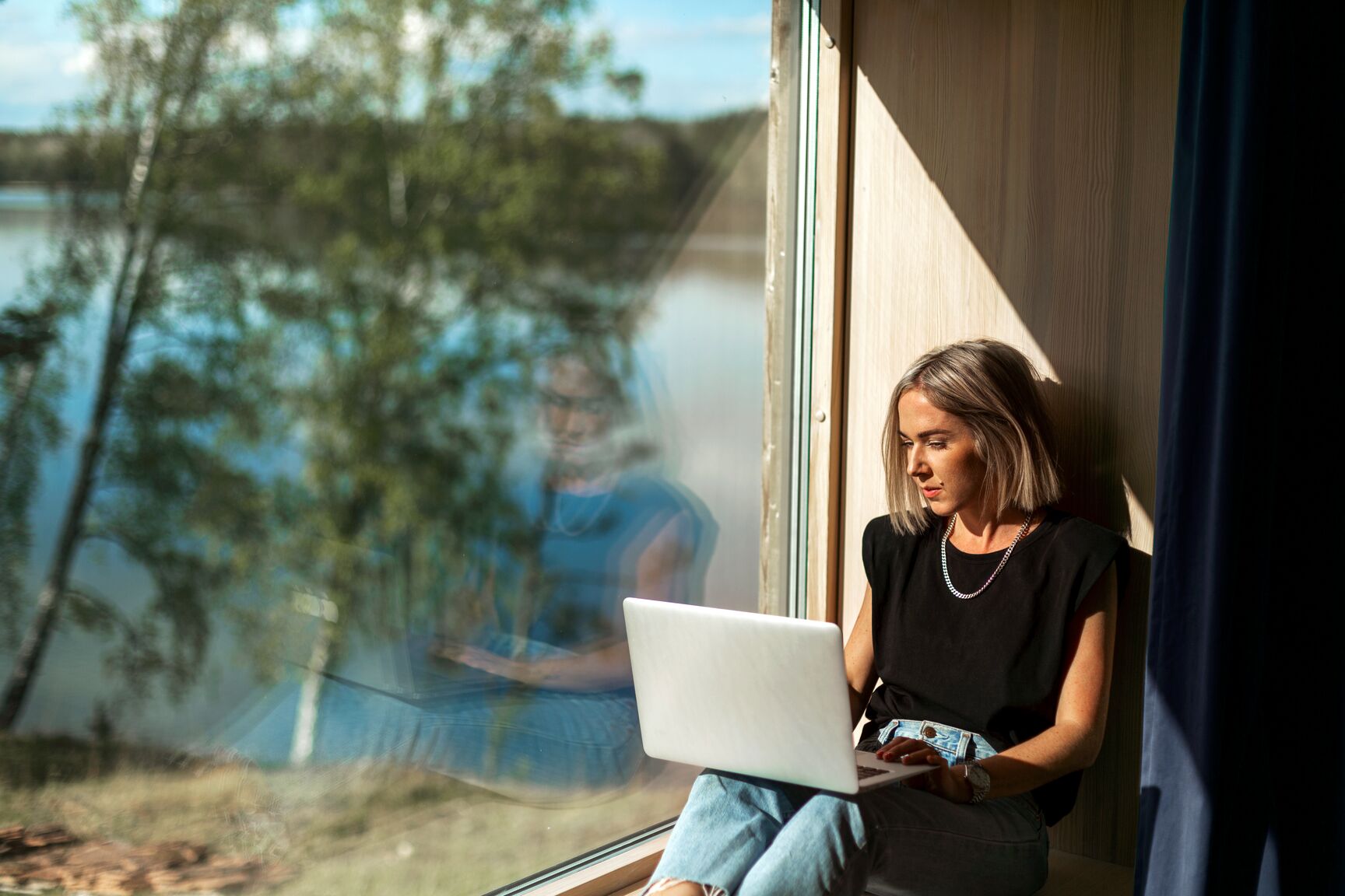 woman-working-on-laptop-close-to-window
