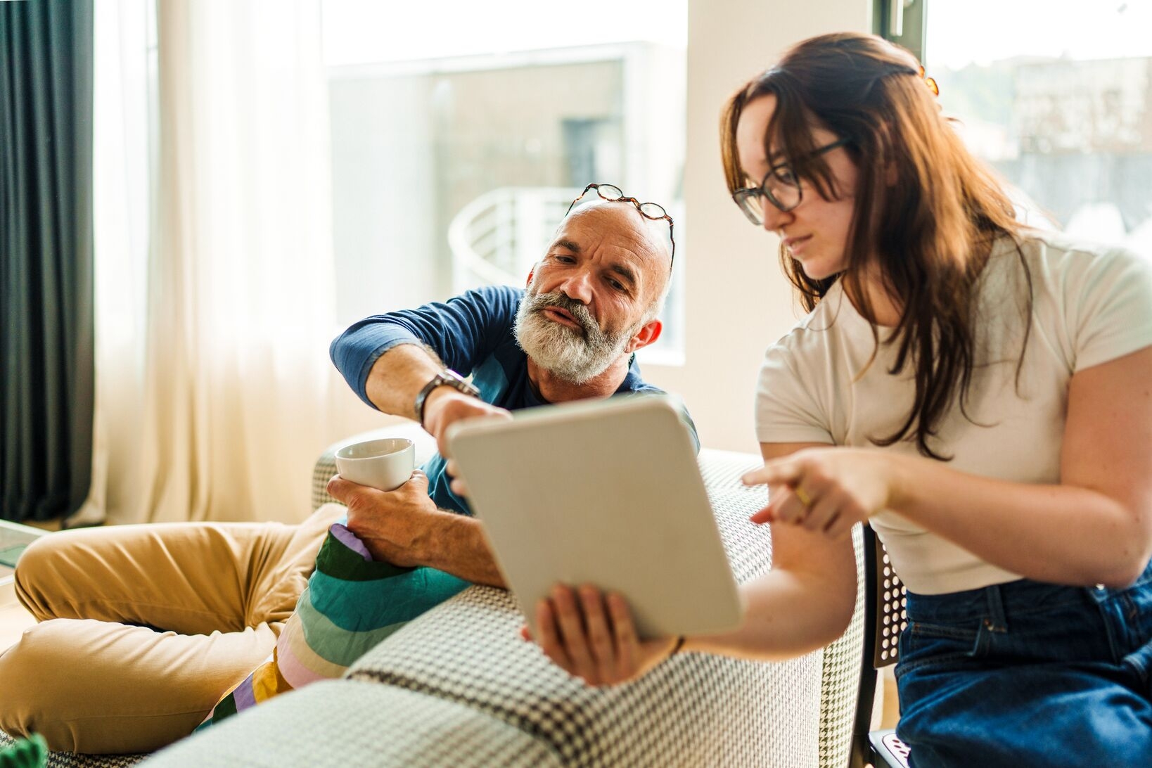 man-and-young-adult-woman-discussing-and-checking-tablet