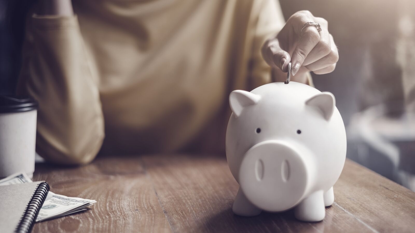 Woman putting coin in piggy bank