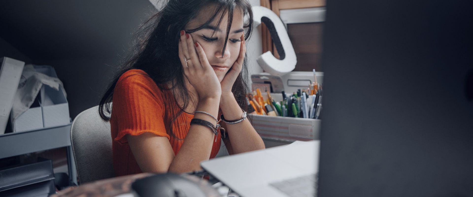 Female teenager feeling stressed studing at home