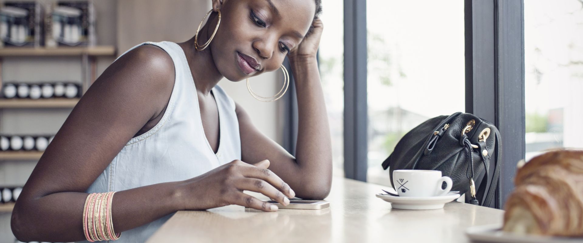 Young woman in café with mobile phone