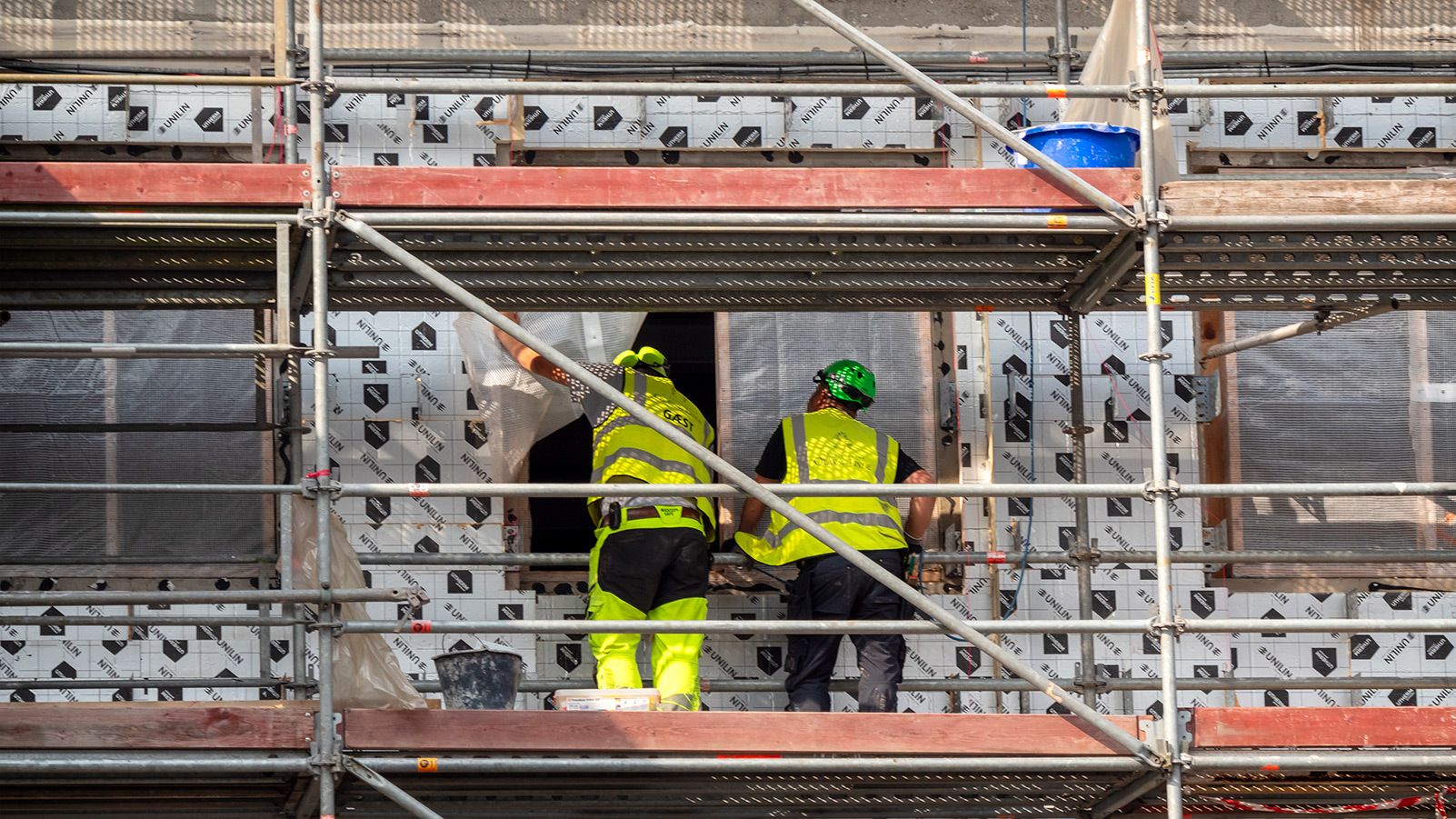 To bygningsarbejdere på en byggeplads i Aarhus – havnebyen i det østlige Jylland i Danmark.