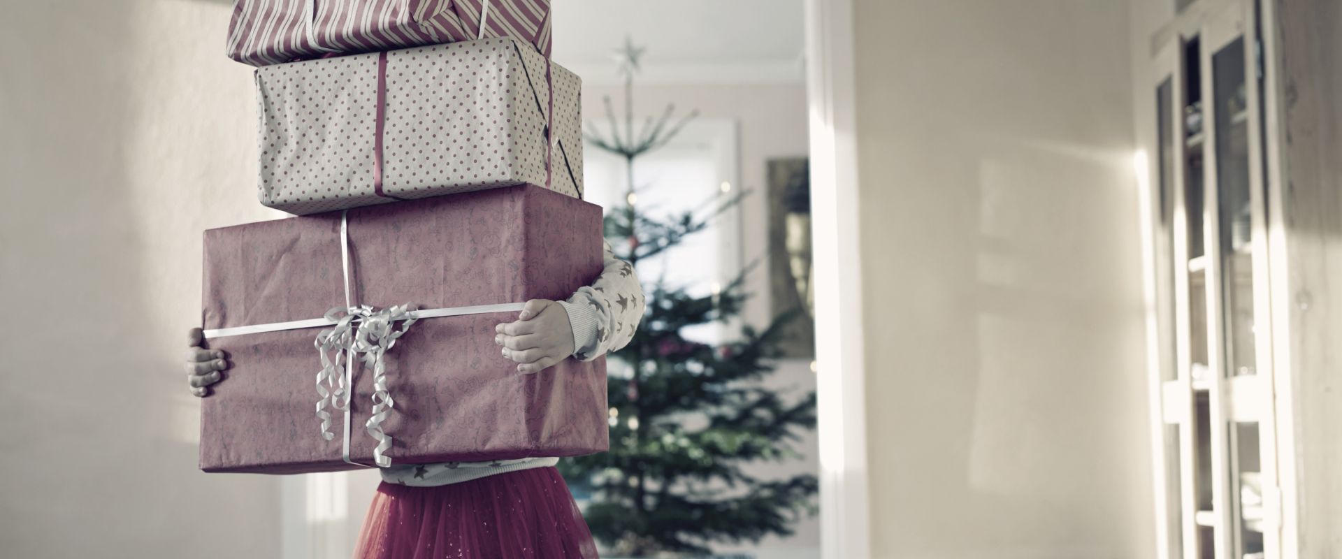 girl-holding-tall-stack-of-christmas-presents