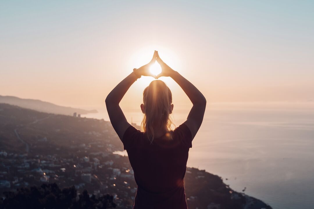 Woman doing yoga at sunrise