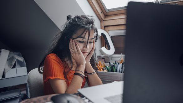 Female teenager feeling stressed studing at home