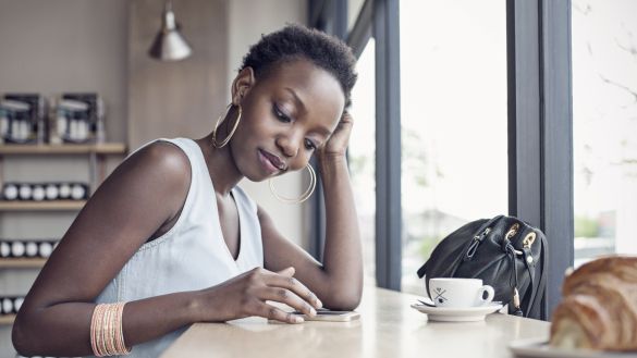 Young woman in café with mobile phone