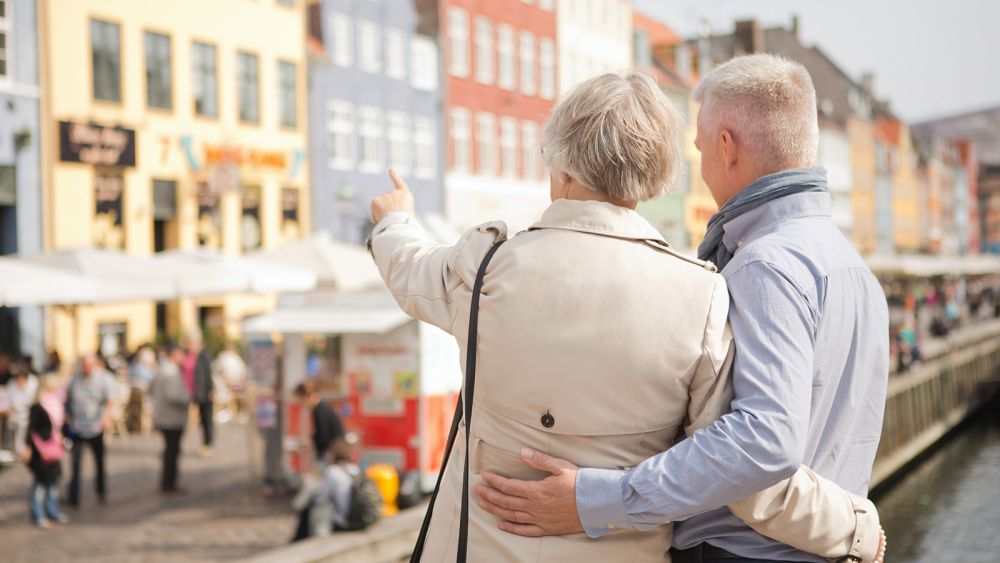 Muntert ældre par kigger på vartegn i Nyhavn, København, Danmark.